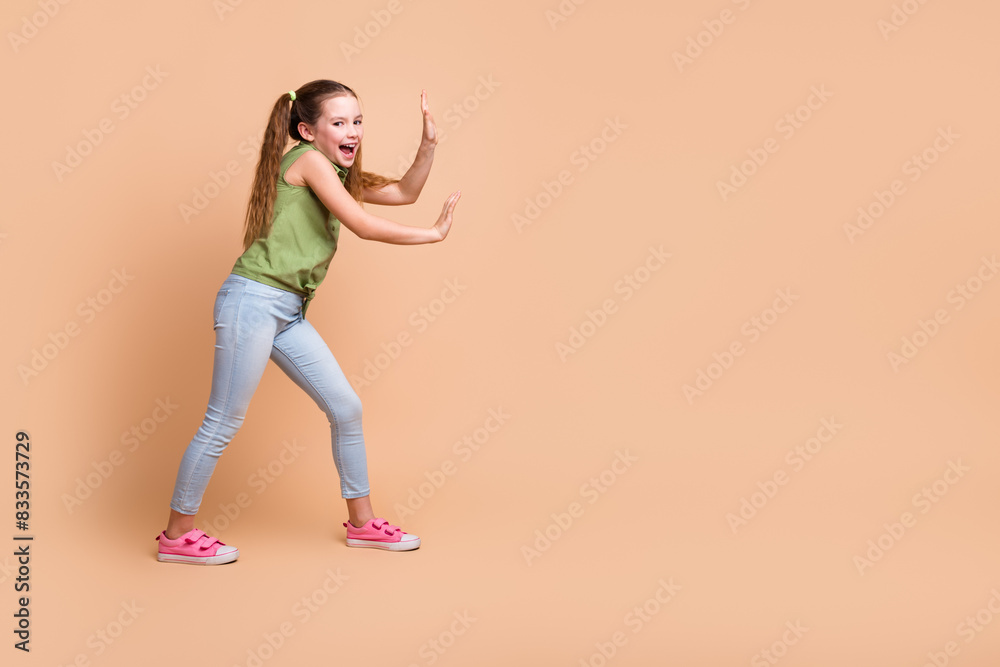 Photo of excited girl push hands empty space isolated pastel color background Photo of excited girl push hands empty space isolated pastel color background