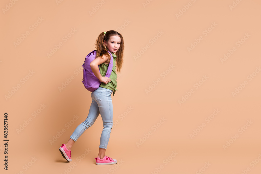Photo of kid girl go walk hold rucksack copyspace isolated pastel color background