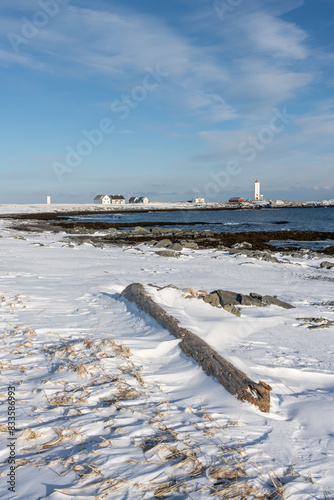 A Lighthouse on the rugged coast of the Barents Sea on a sunny winter day, Berlevåg Norway photo