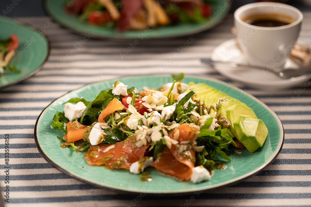Salmon salad with avocado, arugula and feta cheese. Keto diet recipe, Mediterranean cuisine. Salmon salad with avocado, arugula and feta cheese. Keto diet recipe, Mediterranean cuisine.