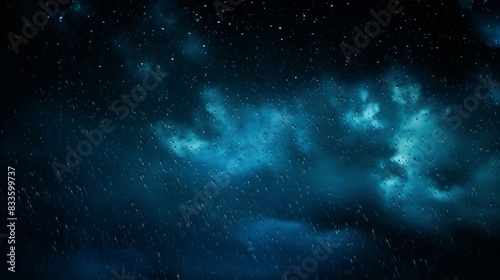 Rain splashing on a darkly blue background at night 