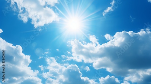 Sun with rays and glare clear blue sky and clouds Sunshine in a blue sky with white cumulus clouds in bright weather