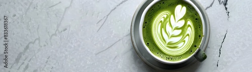 Exquisite Matcha Green Tea Latte with Intricate Latte Art Against Minimalistic Background