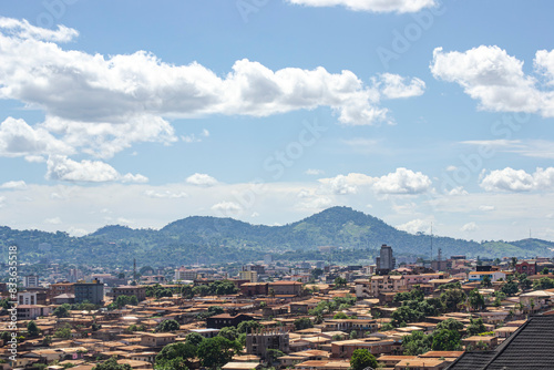 panorama of the yaounde city, Panoramic aerial view of the city of yaounde in Cameroon, with a mountain range in the background, and a beautiful blue sky with clouds.