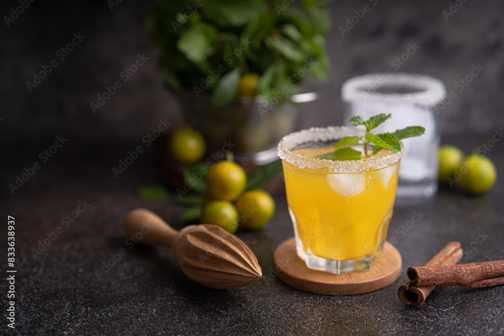 Fresh summer orange mojito with tangerine orange, mint and ice on black background Fresh summer orange mojito with tangerine orange, mint and ice on black background