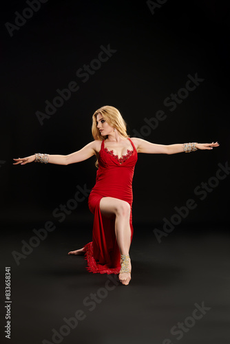 Young woman in red dress gracefully dancing.