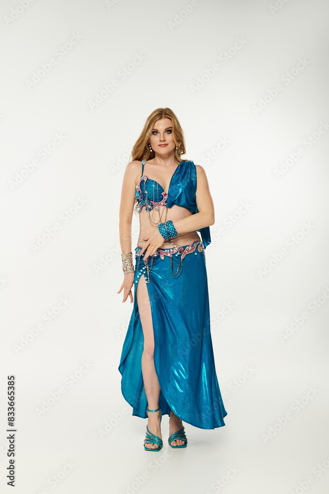 Young woman in blue dress gracefully posing for a dance performance. Young woman in blue dress gracefully posing for a dance performance.