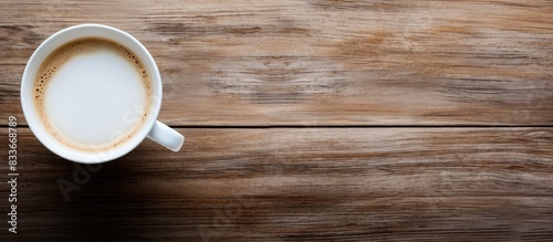 A top down view of a white cup filled with a hot beverage ready to be enjoyed The image is a long banner with ample copy space