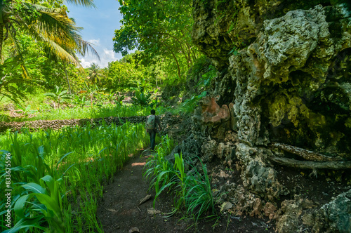 Gunungkidul, Indonesia - December 26, 2016. Asian man walks exploring towards Ngelangkap beach during the day.