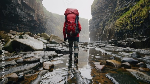 a hiker clad in appropriate outdoor gear, including a backpack and sturdy hiking boots, standing confidently on a rocky terrain. photo
