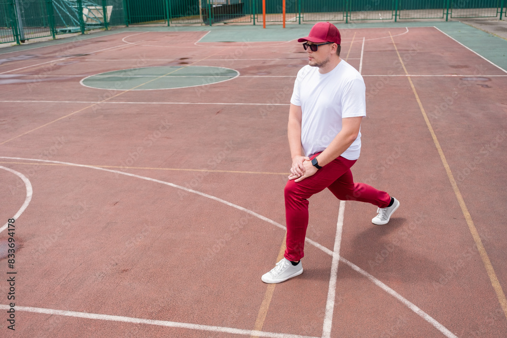 Athletic bearded man warms up before workout at the stadium Athletic bearded man warms up before workout at the stadium