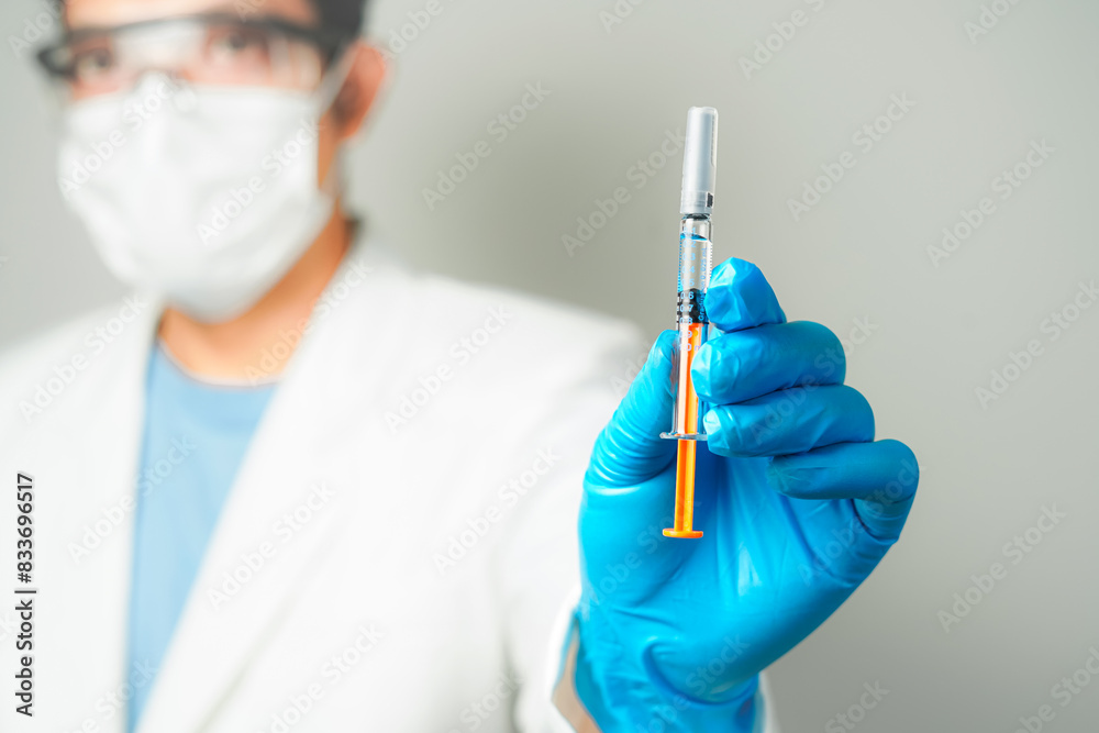 doctor or scientist holding a syringe in blue gloves