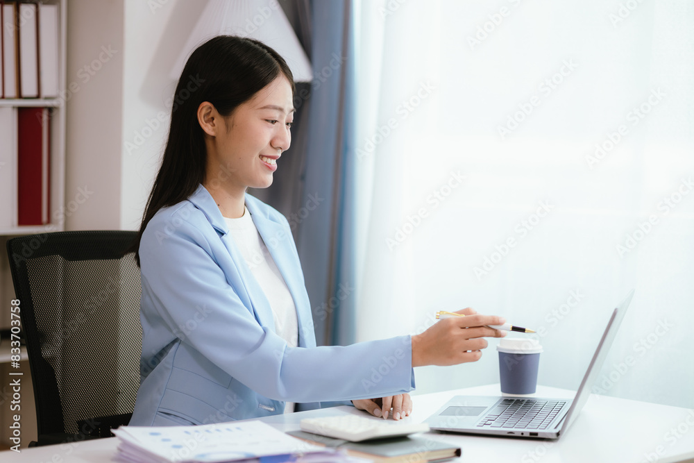 Happy young woman uses laptop computer for virtual meeting Have a video call at home Cheerful Asian woman communicating with colleagues and friends Happy young woman uses laptop computer for virtual meeting Have a video call at home Cheerful Asian woman communicating with colleagues and friends