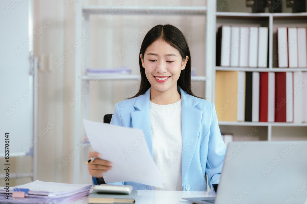 Portrait of a young Asian business woman working on Stacks of paper files to find and check unfinished documents in a folder document in a busy job. Portrait of a young Asian business woman working on Stacks of paper files to find and check unfinished documents in a folder document in a busy job.