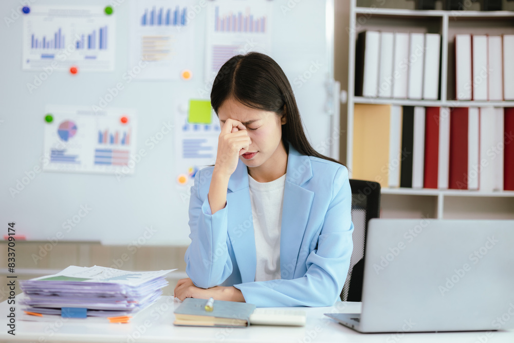 Asian businesswoman who is suffering from headache and stress due to overwork. Asian businesswoman who is suffering from headache and stress due to overwork.