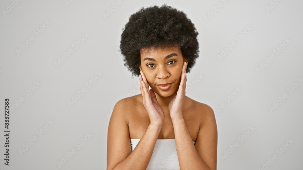 A beautiful african american woman with curly hair poses confidently against a white background, exuding elegance and youth. A beautiful african american woman with curly hair poses confidently against a white background, exuding elegance and youth.