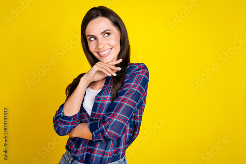 Photo portrait of lovely young lady look empty space interested dressed stylish plaid garment isolated on yellow color background © deagreez