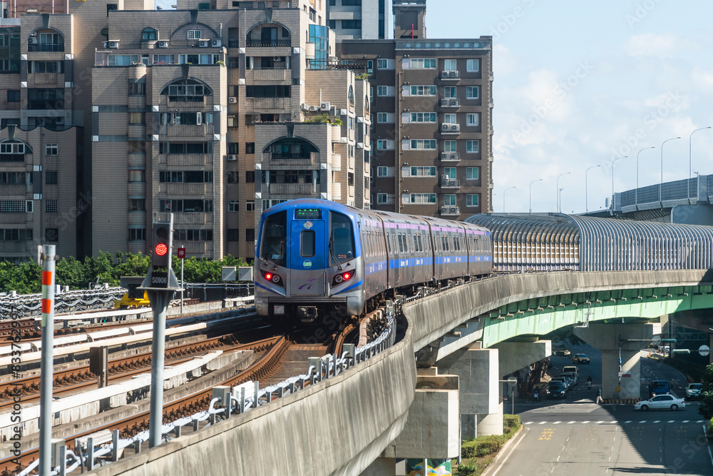 Naklejka premium Taoyuan, Taiwan- November 21, 2023: View of a Taoyuan International Airport line train running on the elevated track of the Taoyuan Mass Rapid Transit System.