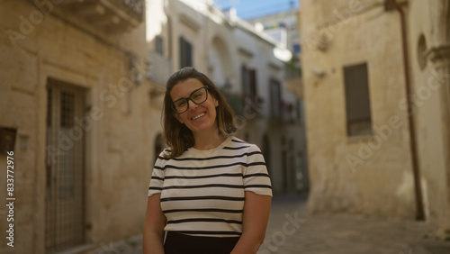 A young  hispanic  beautiful woman smiling in the historic streets of lecce  a charming town in puglia  italy  bathed in warm sunlight.
