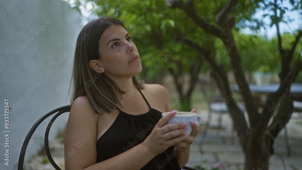 Young hispanic woman enjoying coffee outdoors in an italian cafeteria. Young hispanic woman enjoying coffee outdoors in an italian cafeteria.