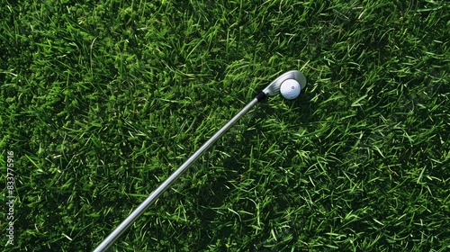 A close-up view of a golf club next to a ball, positioned in lush green grass, ready for a swing