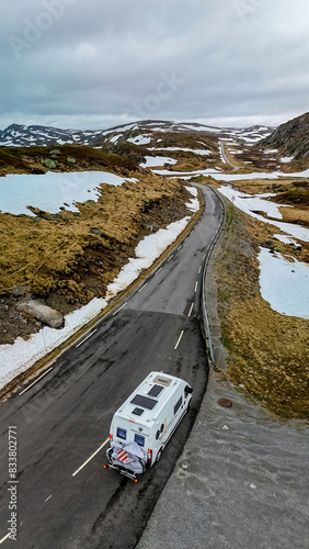 camper van, Caravan trailer, or camper RV at the Lyse road covered with snow to Krejag Norway Lysebotn, road covered with snow, drone aerial view photo