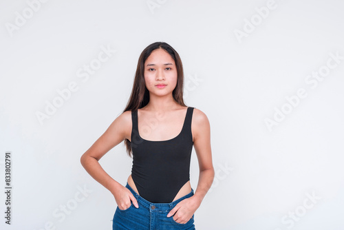 Front view of a young asian woman in a black bodysuit and shorts, posing confidently. Isolated on a white background. © Mdv Edwards
