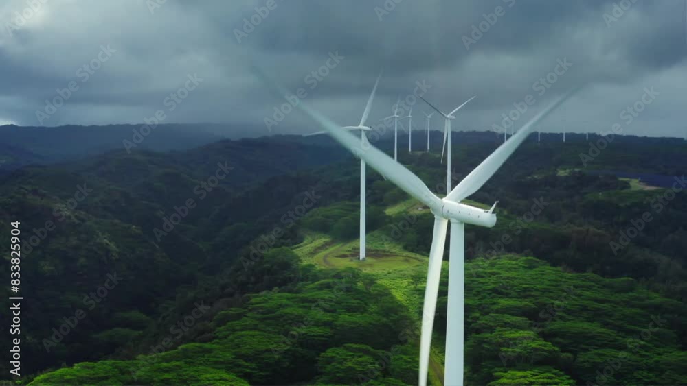 Aerial View of Green Valley with Wind Turbines and Cloudy Sky, Showcasing Renewable Energy Harmony