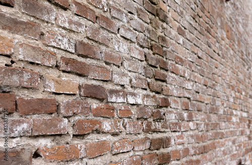 Perspective view of a wall with red aged bricks Old urban textured background 