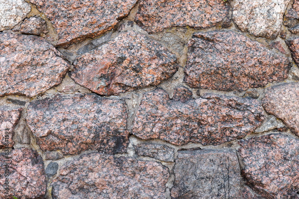Old stone wall made of massive granite blocks, background texture Old stone wall made of massive granite blocks, background texture