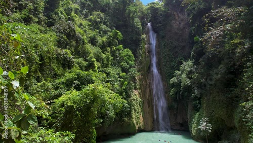 4K Aerial Drone video of beautiful Mantayupan Falls surrounded by jungle with a suspension bridge on a sunny day, Cebu, Philippines photo