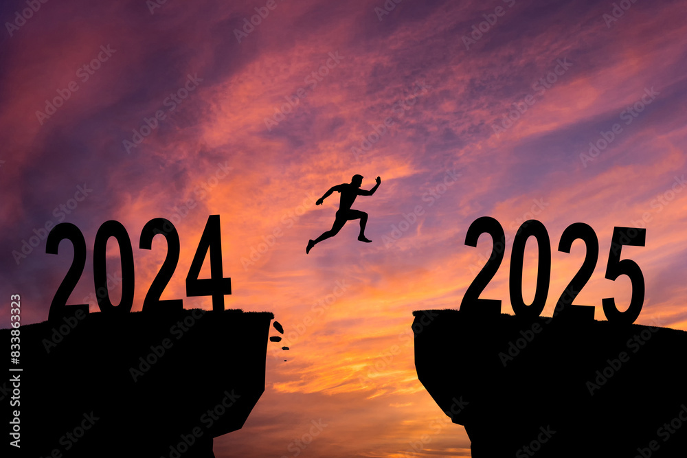 Merry Christmas in 2025. A young man jump between 2024 and 2025 years over the sun and