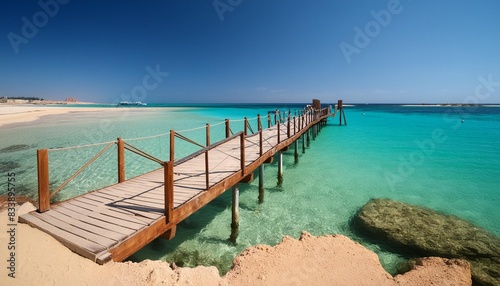 wooden pier at orange bay beach with crystal clear azure water and white beach paradise coastline of giftun island mahmya hurghada red sea egypt