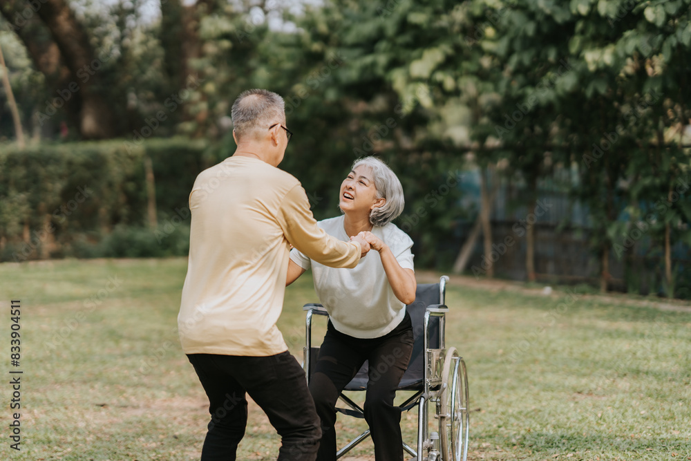 Elderly couple husband and wife happy asian people giving love and care Wheelchair in the park relaxing in spring, relaxing and walking outside at the park. Elderly couple husband and wife happy asian people giving love and care Wheelchair in the park relaxing in spring, relaxing and walking outside at the park.