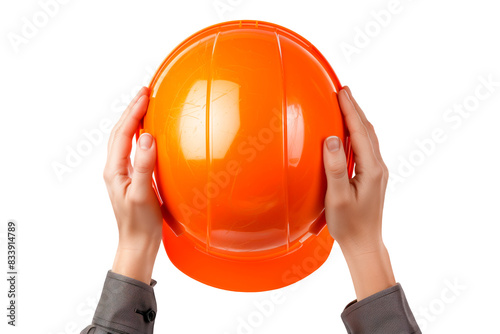 A man's hands hold a builder's helmet on a white or transparent background. Close-up of a builder's hands holding an orange helmet. Graphic design element on the theme of construction. photo