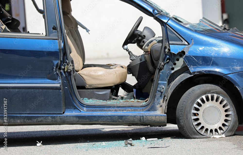 Car completely destroyed with windows on the ground and a flat tire Car completely destroyed with windows on the ground and a flat tire