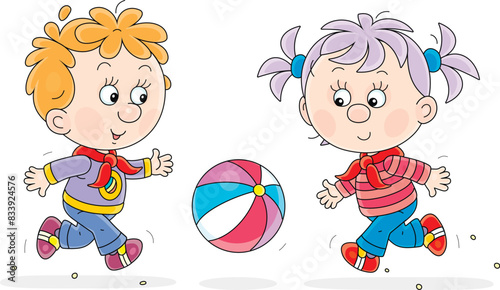 Funny little girl and boy merrily running and playing with a colorful striped ball on a playground in a park, vector cartoon illustration on white