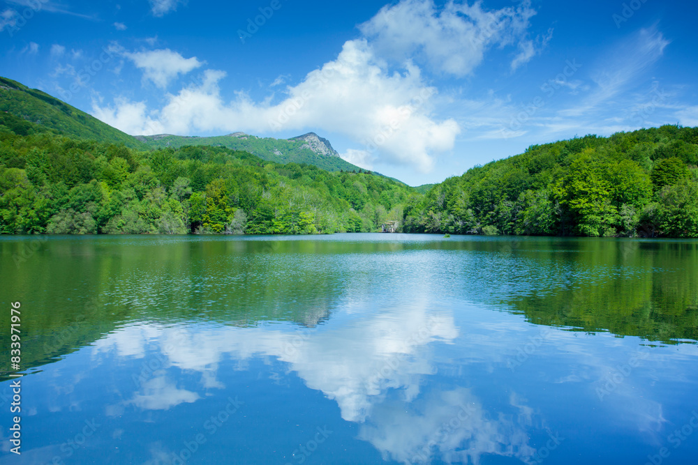 Santa Fe reservoir in Montseny, Catalonia, sunny day to enjoy its wonderful views, horizontal, reflections of sky and clouds, forest, green, blue, water, tranquility, balance. Santa Fe reservoir in Montseny, Catalonia, sunny day to enjoy its wonderful views, horizontal, reflections of sky and clouds, forest, green, blue, water, tranquility, balance.