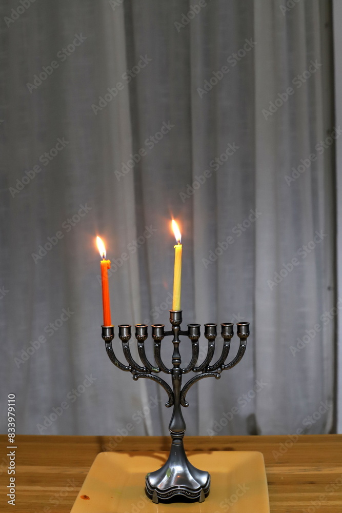 A burning wax candle stands on the table. A burning wax candle stands on the table.