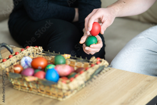 easter egg tapping, mother and son egg tapping next to basket with easter eggs, selective focus, close up of hands egg tapping