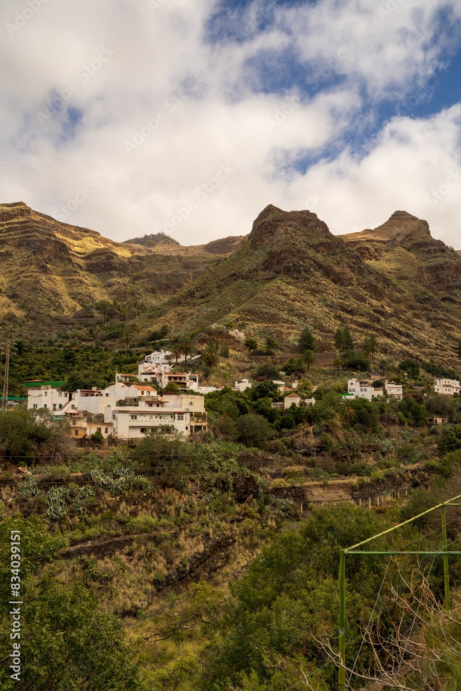 Houses on a rocky terrain mountain of gran canaria in Spain against blue sky in summer