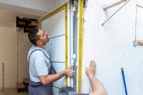 Tableau sur toile Professional carpenters installing an entrance door in a new apartment