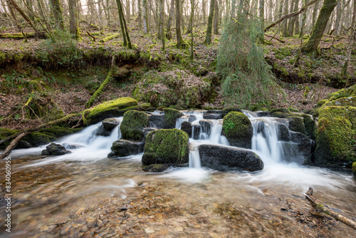 Long exposure of a waterfall flowing through the woods at Combe Park near Watersmeet in Exmoor National Park photo