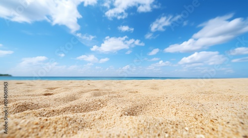 Serene Sandy Beach Under a Sunny Blue Sky with Scattered Clouds