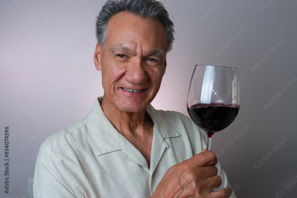 Mature Man smiling and holding up a big glass of red wine Mature Man smiling and holding up a big glass of red wine