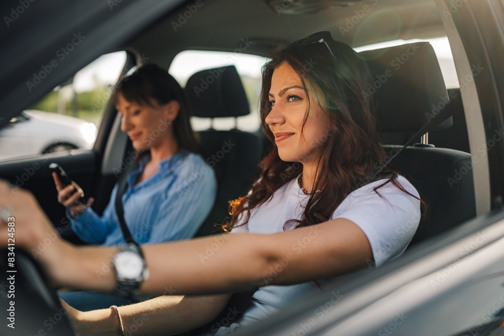 Portrait of trendy female driver driving an automobile on city street. Portrait of trendy female driver driving an automobile on city street.
