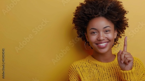 Young Woman Smiling In Yellow Sweater Against Yellow Wall