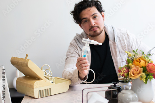 Person with respiratory problems in the living room trying to used a old nebulizer and get confused