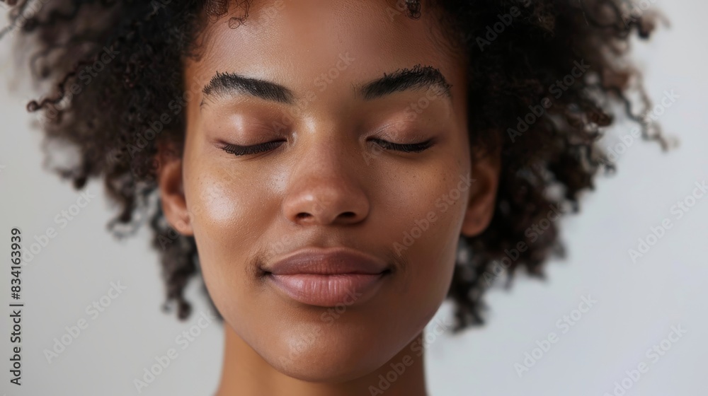 Serene young woman with curly hair and closed eyes