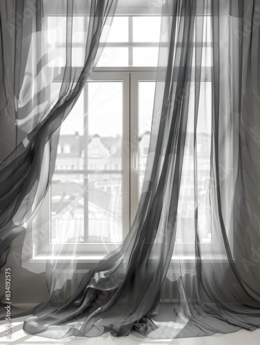 A window with a sheer curtain hanging down from the top, resting on a window sill photo